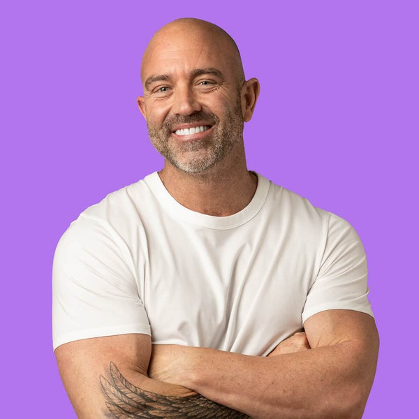 YAAY founder and director Pete Nitschke wearing a white t-shirt with arms crossed on a purple background