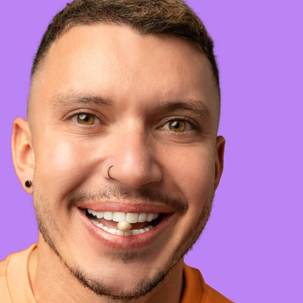 YAAY founder and director Hilton Brandao shows off a YAAY More Than Fibre Capsule in his teeth against a purple background